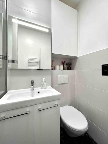 une salle de bain blanche avec des toilettes et un lavabo dans l'établissement Cosy studio Balcon Paris Montparnasse, à Paris