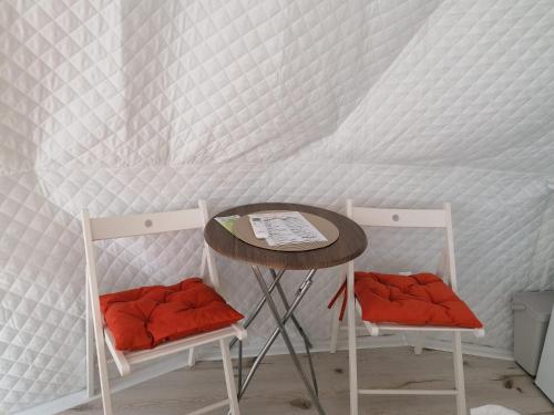 a table and two chairs in front of a wall at Glamping 4 us in Topliţa