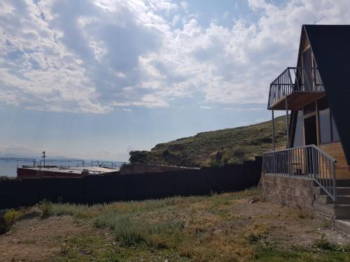a house with a fence next to a hill at Oasis Home on Lake Sevan in Shorzha