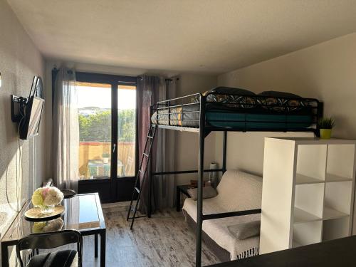 Cette petite chambre comprend des lits superposés et une table. dans l'établissement LE SPOT Studio'Hotel 