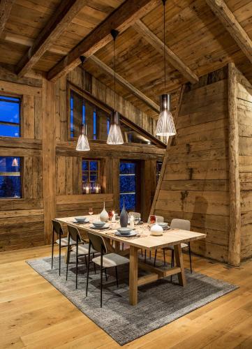 une salle à manger avec une table, des chaises et des lumières dans l'établissement Chalet Drozin - Fenil LUXE & COZY 11 pers, à Abondance