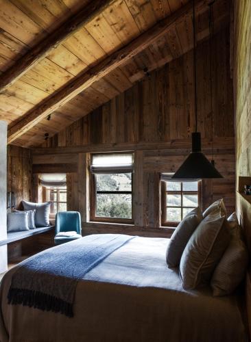 une chambre avec un grand lit dans une pièce aux murs en bois dans l'établissement Chalet Drozin - Fenil LUXE & COZY 11 pers, à Abondance
