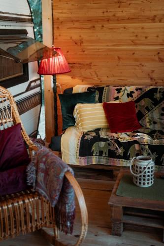 a bedroom with a bed and a table with a lamp at Каравана GYPSY in Chernomorets