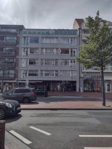 a large building with cars parked in front of it at Prince's165 in Knokke-Heist
