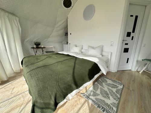 a bedroom with a bed with a green blanket at Glamping 4 us in Topliţa