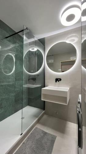 une salle de bain avec une douche, un lavabo et un miroir dans l'établissement Appartement 52m2, neuf, à deux pas de la Gare, à Poissy