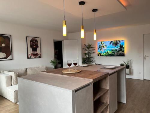 une cuisine avec un îlot avec deux verres de vin dans l'établissement Appartement 52m2, neuf, à deux pas de la Gare, à Poissy