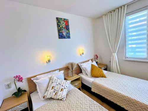 a small room with two beds and a window at Къща за гости Веселина - Ивайловград in Ivaylovgrad