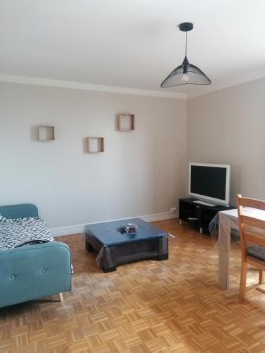 un salon avec un canapé et une télévision dans l'établissement 3 chambres Compiègne, à Compiègne
