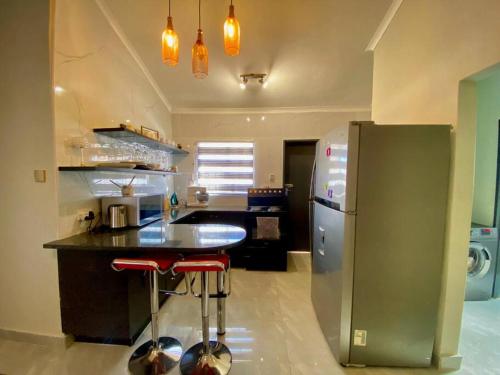 a kitchen with a counter and a refrigerator at Down Town Delight - 2BR Budget Retreat in Gaborone