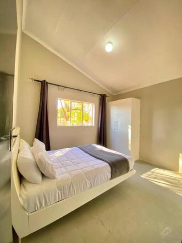 a bedroom with a large bed with a window at Down Town Delight - 2BR Budget Retreat in Gaborone