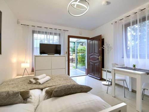 Un dormitorio con una cama, un escritorio y un televisor. en Small holiday apartment, en Łukęcin