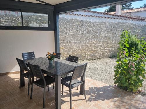 une table noire et des chaises sur une terrasse dans l'établissement Séjour en famille à Avail, à Dolus-d'Oléron