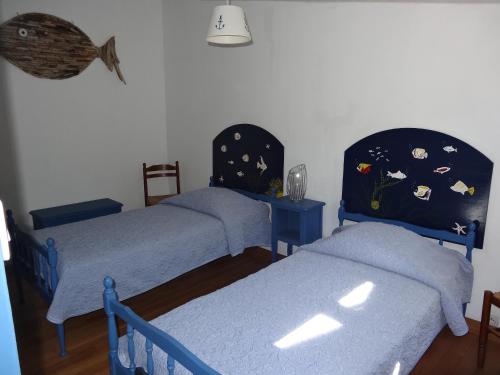 Cette chambre comprend 2 lits avec des draps bleus. dans l'établissement Séjour en famille à Avail, à Dolus-d'Oléron