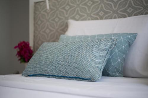 a blue pillow sitting on top of a bed at Aurora - Rooms & Suites - Spetses in Spetses