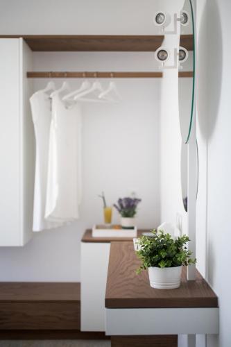 a bathroom with a table with two potted plants on it at Aurora - Rooms & Suites - Spetses in Spetses