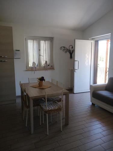a kitchen and dining room with a table and a couch at Dimora San Salvatore in LʼAquila