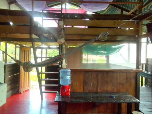 a room with a hammock and a bench in a house at Camping Fungi in Puerto Nariño
