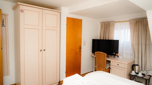 a bedroom with a bed and a desk and a television at Zur-Erholung Büsum in Büsum