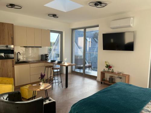 a living room with a bed and a kitchen at Apartament Słoneczny widok boczny na jezioro in Charzykowy