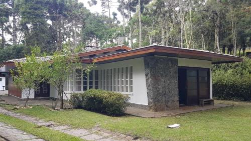 a small house in a yard with a tree at Huluan Alto da Boa Vista in Campos do Jordão