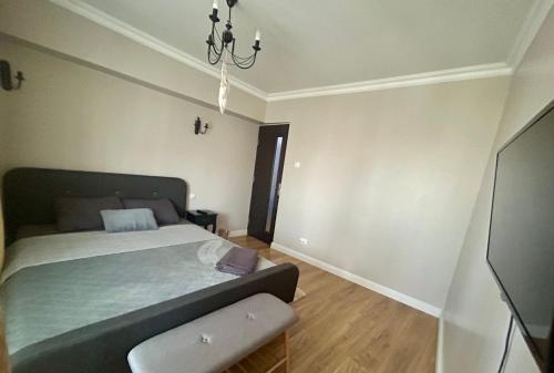 a bedroom with a bed and a television in it at Georgiana’s central apartment in Buzău