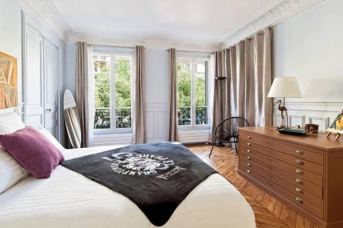 - une chambre avec un lit, une commode et des fenêtres dans l'établissement CAVALIER DES LIONS 2bed 2 and half baths, à Paris