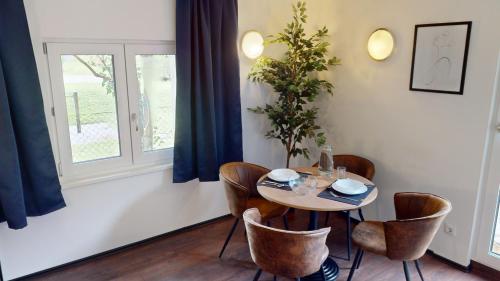 a dining room with a table and chairs and a window at CROWN LIVING Design Loft, Küche, Bibliothek, Gartensitzplatz in Lustenau