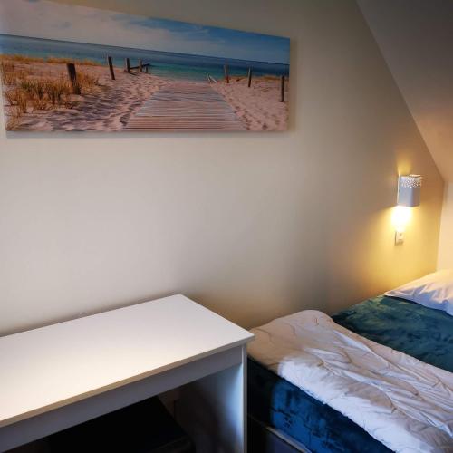 une chambre avec un bureau et un tableau représentant une jetée dans l'établissement Gîte de l'océan, vue mer avec piscine, à Guidel-Plage