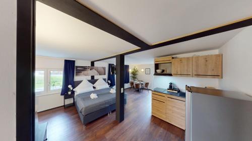 a bedroom with a bed and a desk in a room at CROWN LIVING Design Loft, Küche, Bibliothek, Gartensitzplatz in Lustenau
