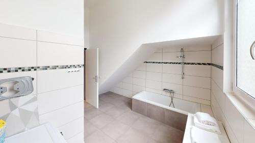a white bathroom with a tub and a sink at CROWN LIVING Design Loft, Küche, Bibliothek, Gartensitzplatz in Lustenau