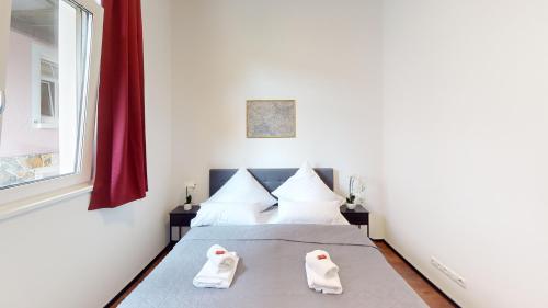a bedroom with a bed with slippers on it at CROWN LIVING Design Loft, Küche, Bibliothek, Gartensitzplatz in Lustenau