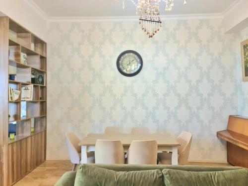 a dining room with a table and a clock on the wall at DêlMar 22 in Mardakan