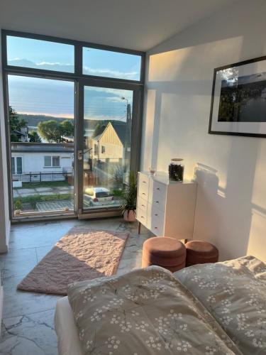 a bedroom with a bed and a large window at Apartament Turystyczny z widokiem na jezioro in Charzykowy