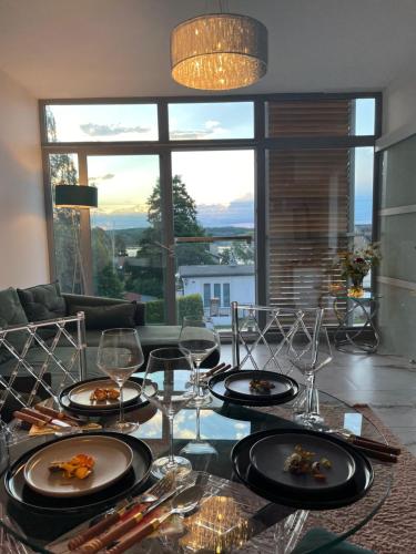 a dining room table with plates and wine glasses at Apartament Turystyczny z widokiem na jezioro in Charzykowy