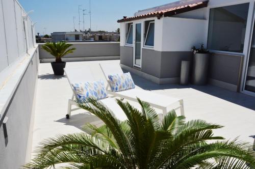 a patio with a white bench on a roof at Marimar Apartment in Bari