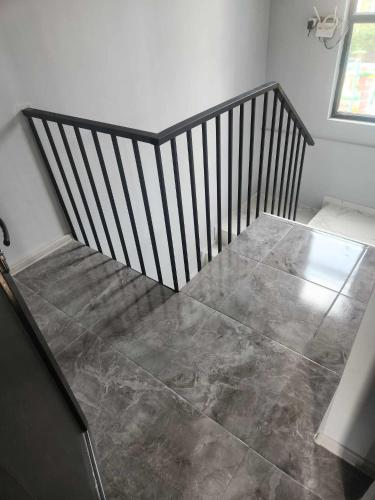 a stairway with a wooden railing and a tile floor at Blue Horizon Apartments in Ureki