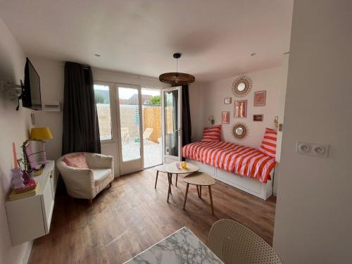 Cette chambre comprend un lit, un canapé et une table. dans l'établissement Appartements - Riva Bella, à Ouistreham