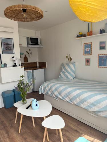 - une chambre avec un lit, une table et deux chaises dans l'établissement Appartements - Riva Bella, à Ouistreham