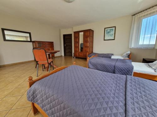 a hotel room with two beds and a desk at Siedlisko Żurawie in Zamarte