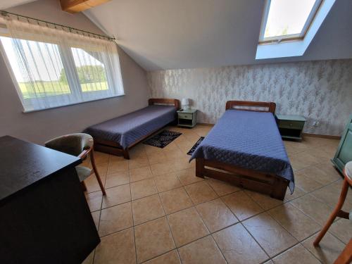 a room with two beds and two windows at Siedlisko Żurawie in Zamarte