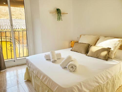 a bedroom with a white bed with towels on it at Estudio Salinas in Tarragona