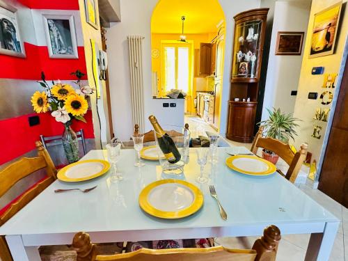 a dining room table with yellow plates and a bottle of wine at The Comfort apartment in La Spezia