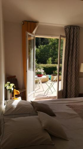 une chambre avec un lit et une porte coulissante en verre dans l'établissement Les chambres des Baronnies, à Buis-les-Baronnies