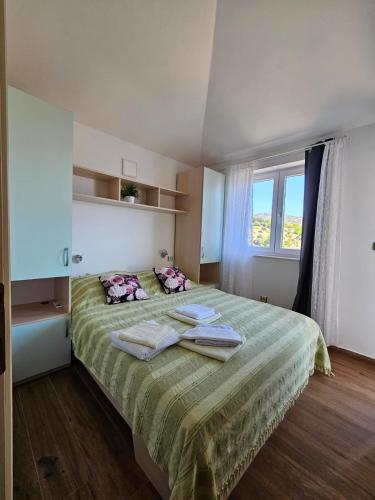 a bedroom with a bed with two towels on it at Apartments Villa Šibenik in Primošten