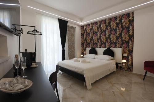 a bedroom with a large bed with a floral wallpaper at De Spuches House in Caccamo