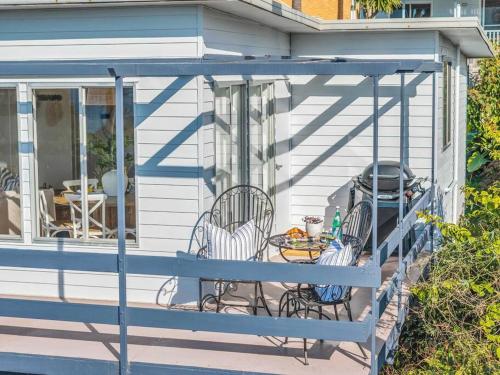 a porch of a house with a table and chairs at High Noon in Eden
