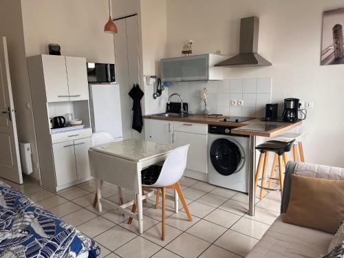 une cuisine avec une table et une cuisine avec une cuisinière dans l'établissement Studio Le Belvedere 2, à Balaruc-les-Bains