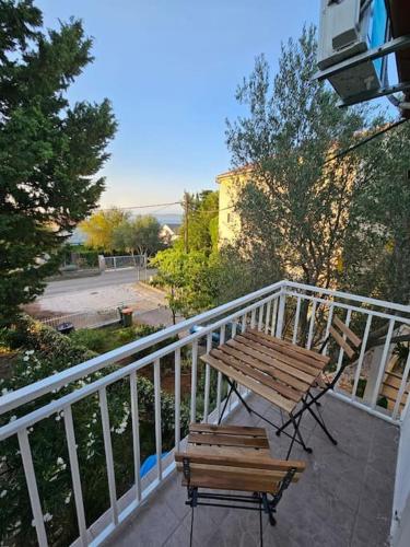 a wooden bench and a table on a balcony at Apartmani Kuzman in Ždrelac