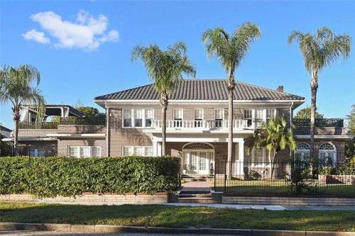 a large house with palm trees in front of it at LUXURY 6000 sqft Mansion in Downtown Orlando Sleeps 12 in Orlando